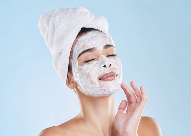 Skincare woman, beauty facial mask and cosmetics after fresh shower, bathroom grooming routine and bodycare on blue background. Feminine face, clean spa pores and healthy pamper treatment complexion. - Foto, imagen