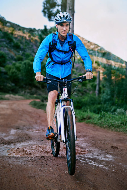 Setting out on his bike ride. a male cyclist riding along a mountain bike trail - Foto, afbeelding