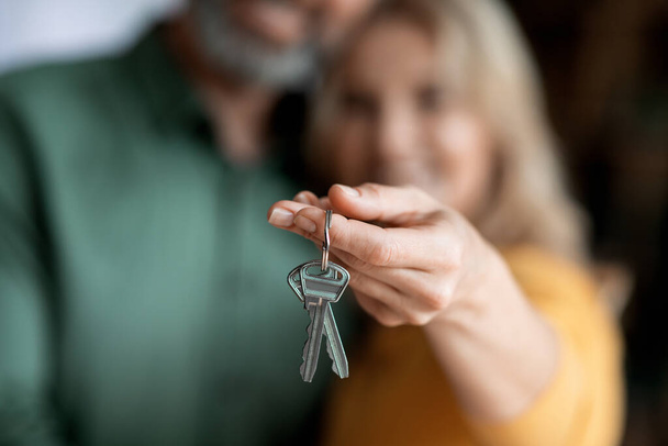 Real Estate Concept. Closeup Shot Of Married Middle Aged Couple Holding Home Keys, Smiling Mature Spouses Celebrating Buying Property, Moving To Their Own House, Selective Focus, Cropped - Fotó, kép