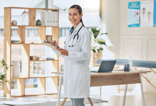 Doctor in an office with a happy portrait for trust, health care insurance and checklist. Vision, success and smile of healthcare worker woman with clipboard and passion or motivation for her career. - Photo, image