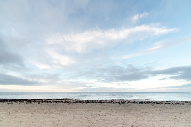 baltic beach in fall with clouds and waves towards deserted dune - Foto, imagen