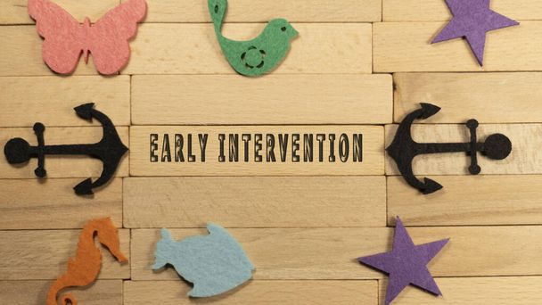Early intervention written on wooden cube. Education and child development - Foto, Bild