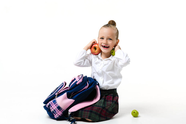 Cute girl in school uniform fooling around collecting a backpack to school Isolated on a white background. - Foto, Bild