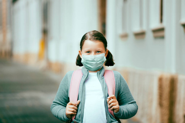 Child with face mask going back to school  - Foto, imagen