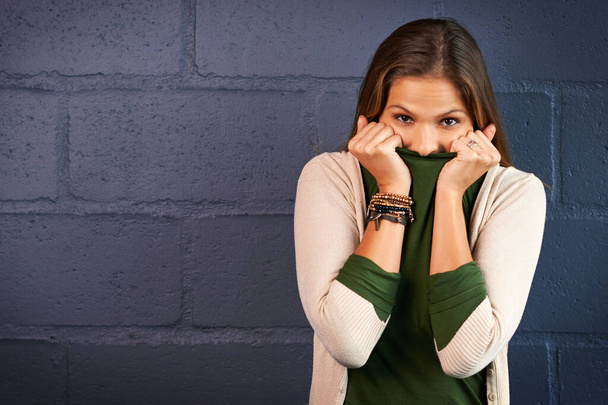 Whoopsie. a young woman covering her mouth against a brick wall background - Фото, изображение