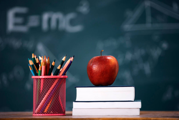 Back to School Concept. Apple, accessories and books against chalkboard. - Fotó, kép
