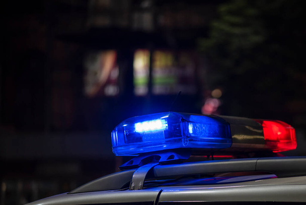 Аварійне світло поліцейського патрулювання автомобіля на вулиці вночі
 - Фото, зображення