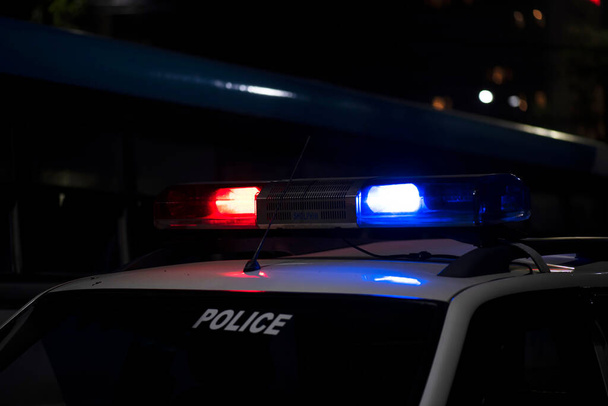 Аварійне світло поліцейського патрулювання автомобіля на вулиці вночі
 - Фото, зображення