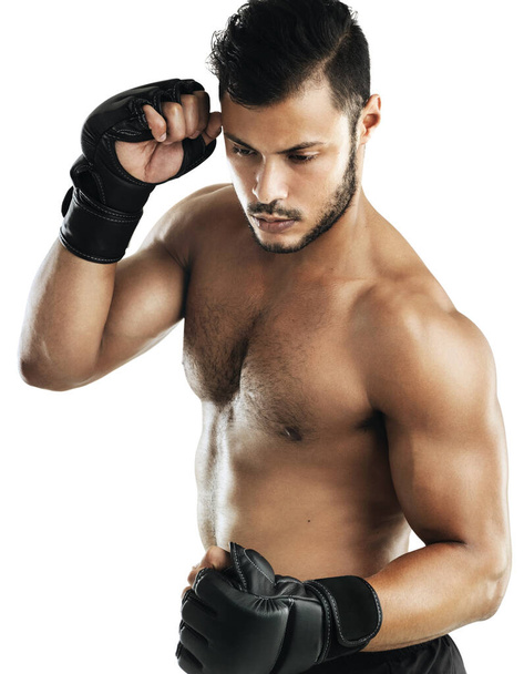 Hes fighting fit. Studio shot of a fit young man wearing boxing gloves against a white background - Photo, image