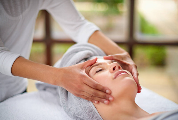 Massaging the stress away. a young woman enjyoing a massage at the day spa - Photo, Image