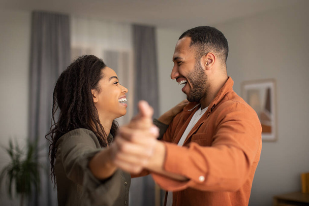 Happy Dating Black Couple Dancing Having Fun Together At Home On Weekend. Joy And Happiness In Marriage, Love And Romantic Relationship Concept. Selective Focus - Фото, изображение