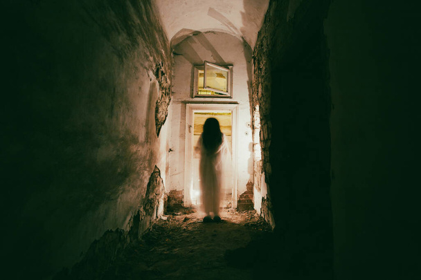 Ghost in abandoned, haunted house. Horror scene of scary spirit of a woman, halloween concept. - Foto, afbeelding