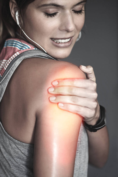 Theres the risk of injury in every sport. a young woman holding her injured shoulder thats highlighted in red - Foto, imagen