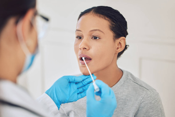 Female patient, healthcare and covid test using swab in mouth to collect specimen at testing center. Medical professional or doctor with gloves for hygiene while working with coronavirus in hospital. - 写真・画像