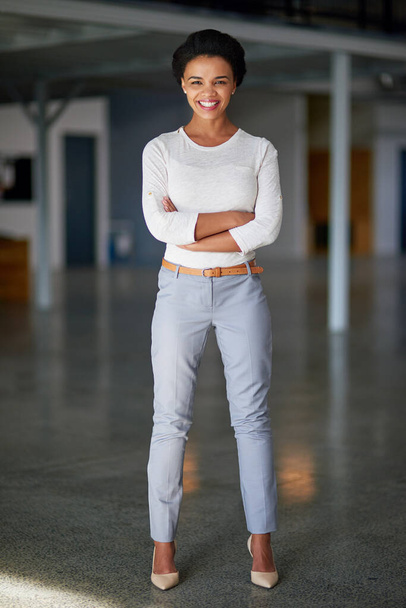 Корпоративна впевненість. Портрет молодої бізнес-леді, що стоїть зі складеними руками в офісі
 - Фото, зображення