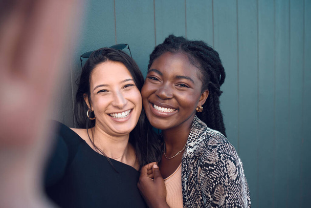 Friends, smile and happy selfie for social media for fashion, street style or trendy clothes women on blue background. Portrait of fun, playing or comic bonding college students for female diversity. - Foto, Imagem