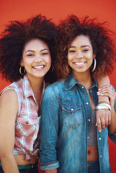 Best friends are like unbiological sisters. two young friends posing against a red background - Foto, Imagem