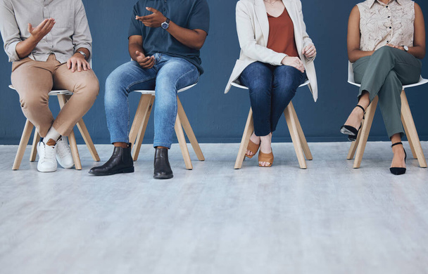 Interview, human resources and recruitment with business people sitting in line on chairs in a studio or waiting area. Entrepreneur application and hiring for a vacancy at a small startup company. - 写真・画像