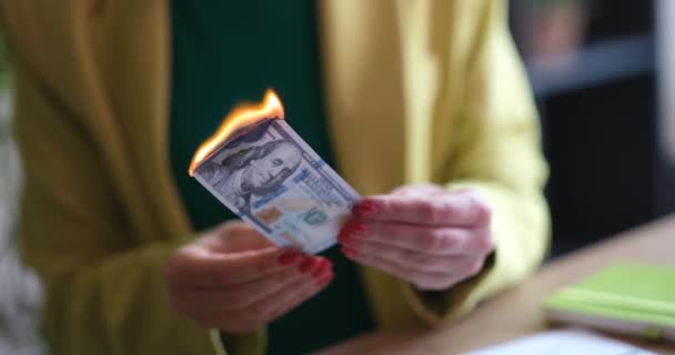 Burning one hundred dollar bill in female hands. Burning money concept - Πλάνα, βίντεο