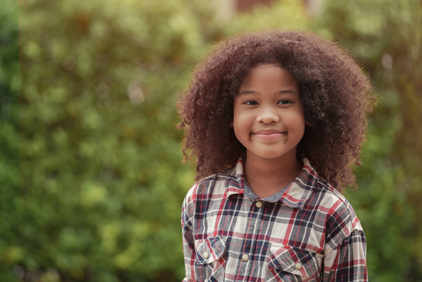 African American kid girl is smiling in the garden or outdoors. - Foto, imagen