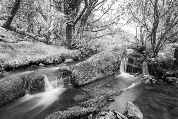Larga exposición del río Weir Water que fluye a través del valle en el puente Robbers en el Parque Nacional Exmoor - Foto, Imagen
