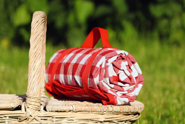 Checkered tablecloth on picnic basket outdoors, closeup - Fotoğraf, Görsel