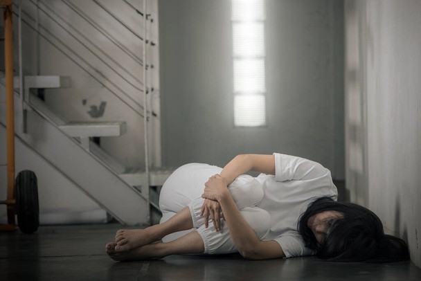 The depressed woman lying down on the floor. Woman abuse concept - Fotoğraf, Görsel