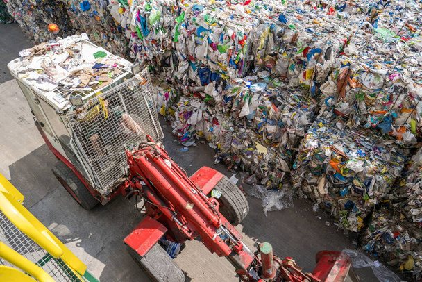 Waste Sorting Station Worker Driving Bulldozer Track Loader Arranging Storage of Bales of Compressed Garbage. - Foto, Bild