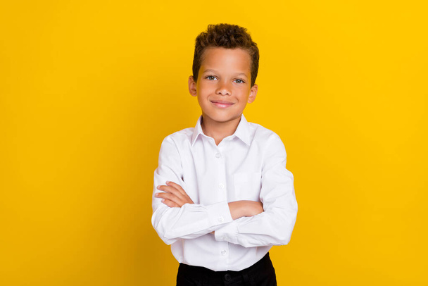Photo of cute boy schoolkid arm folded dressed trendy outfit ready first september wait offline lesson isolated on yellow color background. - Fotografie, Obrázek