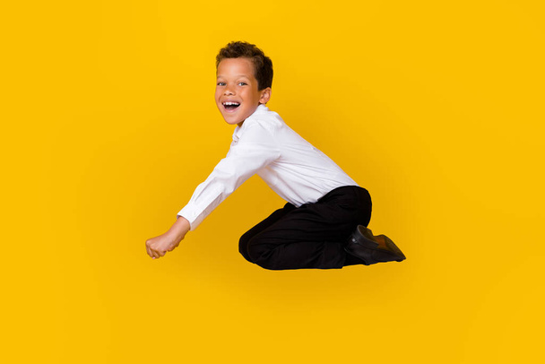 Full length profile portrait of crazy overjoyed person falling have fun isolated on yellow color background. - Photo, image