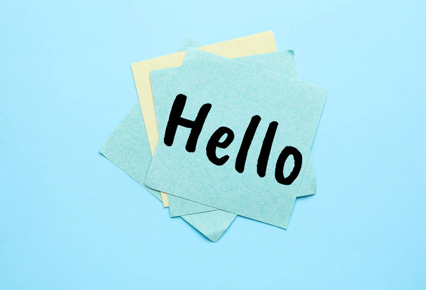 Sticky note with word HELLO on light blue background - Foto, afbeelding