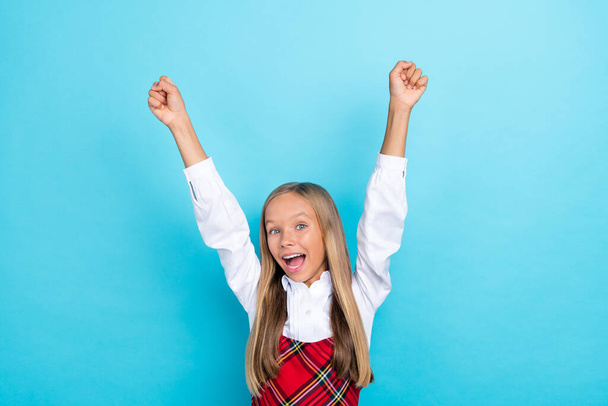 Photo of young smart cute pretty little schoolkid girl fists up winner hooray excited positive isolated on blue color background. - Foto, Bild