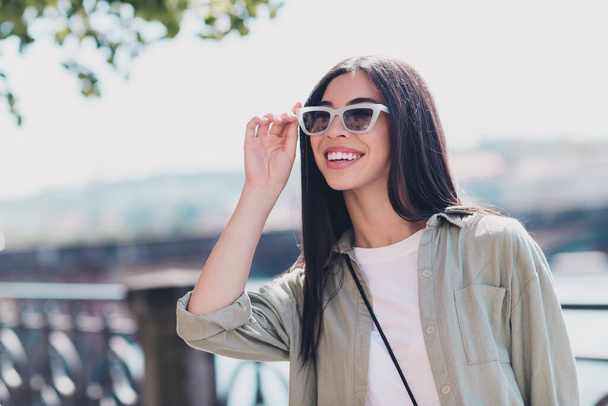 Photo of cute lovely pretty lady tourist listen excursion city facts look with new eyewear enjoy walk outdoors. - Foto, Imagen
