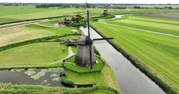 Históricos tradicionales molinos de viento antiguos holandeses en el campo en la naturaleza verde campo de hierba paisaje de la granja con un clima soleado río. - Imágenes, Vídeo