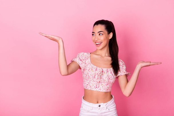 Photo of impressed millennial lady hold look empty space wear top isolated on pink color background. - Photo, Image