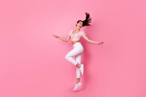 Full length profile photo of hooray millennial brunette lady jump look back wear crop top jeans boots isolated on pink background. - Foto, immagini
