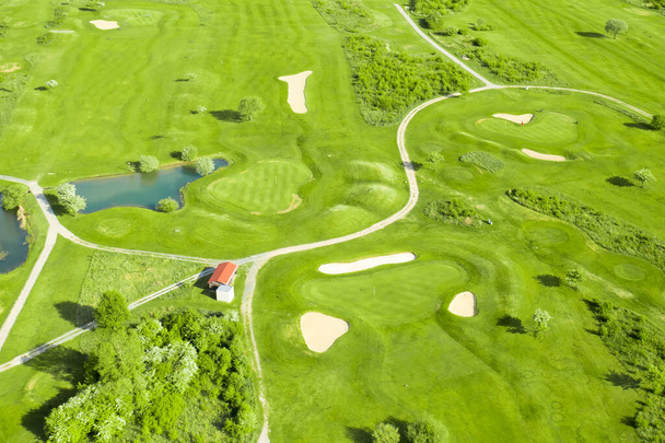 Поле для гольфу з бункером, зеленою травою і ставком, вид з повітря
. - Фото, зображення