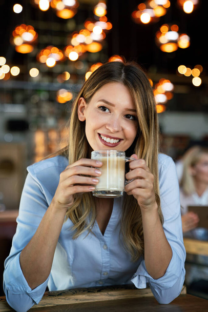 Portrait of happy young successful business woman drinking coffee in a break. - Φωτογραφία, εικόνα