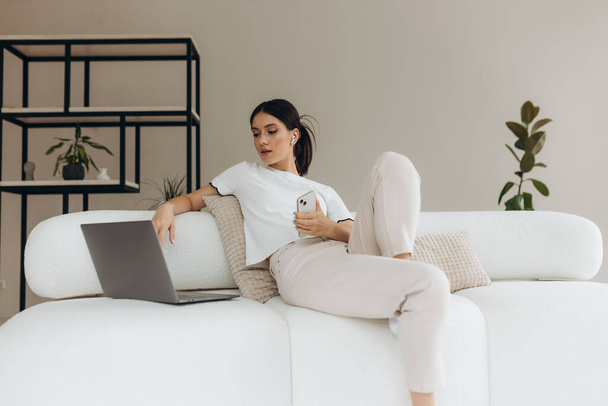 Jeune femme utilisant ses gadgets et se détendre à la maison
 - Photo, image