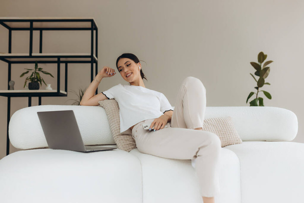 Mujer joven usando sus gadgets y relajarse en casa
 - Foto, Imagen