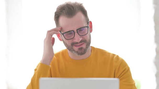 Hombre de mediana edad reaccionando a la pérdida en el ordenador portátil - Foto, imagen