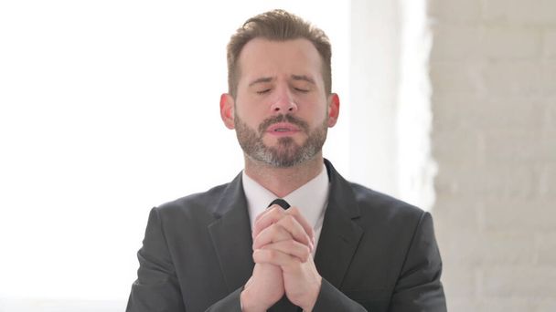 Πορτρέτο του επιχειρηματία προσεύχεται με τα δάχτυλα σταυρωμένα - Φωτογραφία, εικόνα