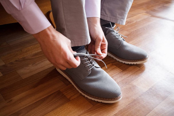 A man groom put on grey shoes - Foto, Bild