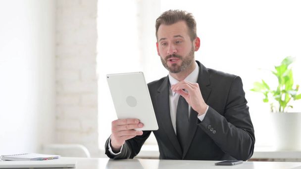 Businessman making Video Call on Tablet in Office - Photo, Image