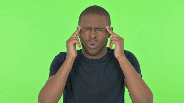 Uomo africano con mal di testa su sfondo verde - Foto, immagini