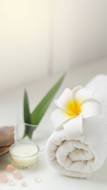 Still life spa setting with pink stone aroma scent candle and plumeria flower. Thai spa massage. Spa treatment cosmetic beauty. Aromatherapy care relax wellness. Aroma and salt scrub healthy lifestyle - Fotografie, Obrázek