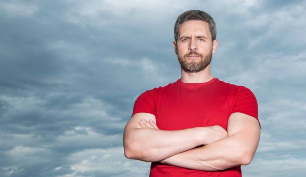 Portrait of grizzled guy sky background. Serious guy keeping arms crossed. Confident guy outdoors, copy space. - Foto, Bild