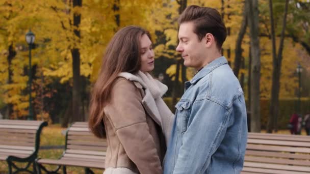 Caucasian young couple lovers married family teenagers stand closeness together in autumn park relationships on romantic date beautiful girl talk with handsome caring boyfriend joy laughing outdoors - Πλάνα, βίντεο