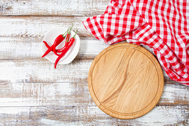 Vista superior enrugada toalha de mesa vermelha, pimenta e prancha na mesa de madeira, zombar - Foto, Imagem