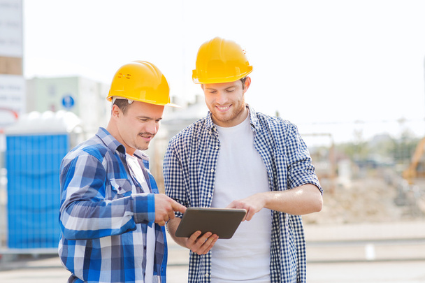 smiling builders in hardhats with tablet pc - Fotografie, Obrázek
